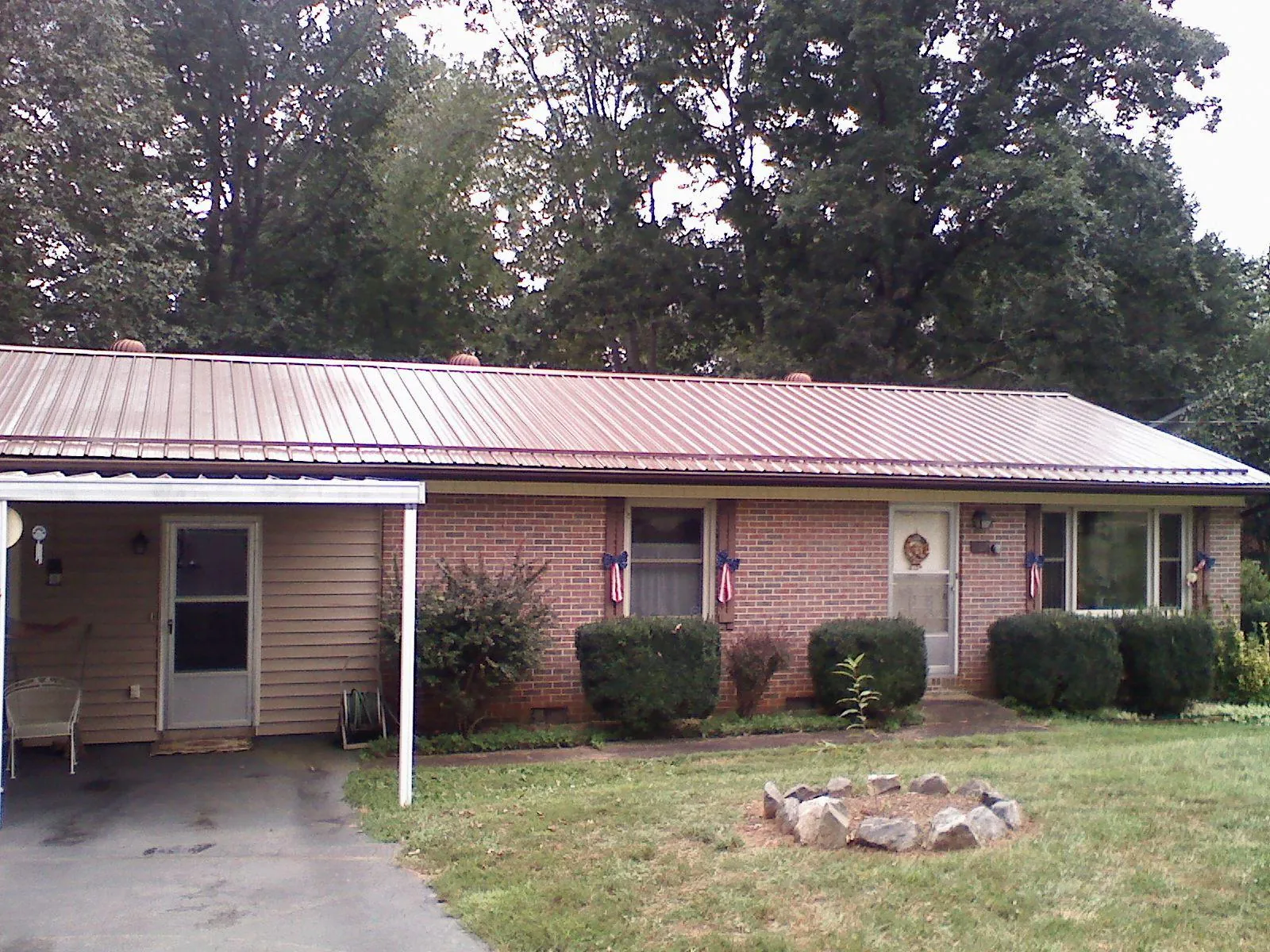 Bronze metal roof and carport on a brick ranch home — Roof Repair work by our crew in Carbon Hill