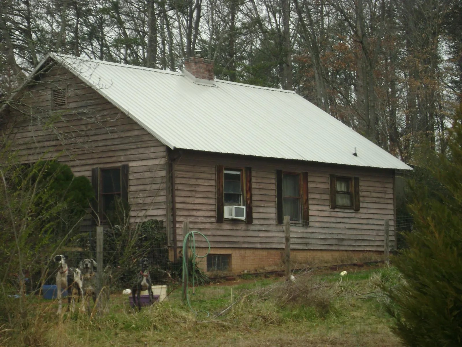 White metal roof on an old wood sided farmhouse, from a Metal Roof Installation job in Carbon Hill